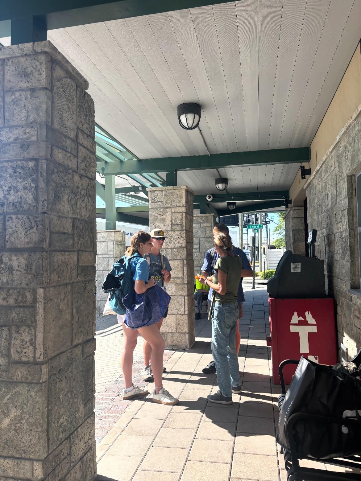 Volunteers talking with someone under a covered walkway in downtown Tampa