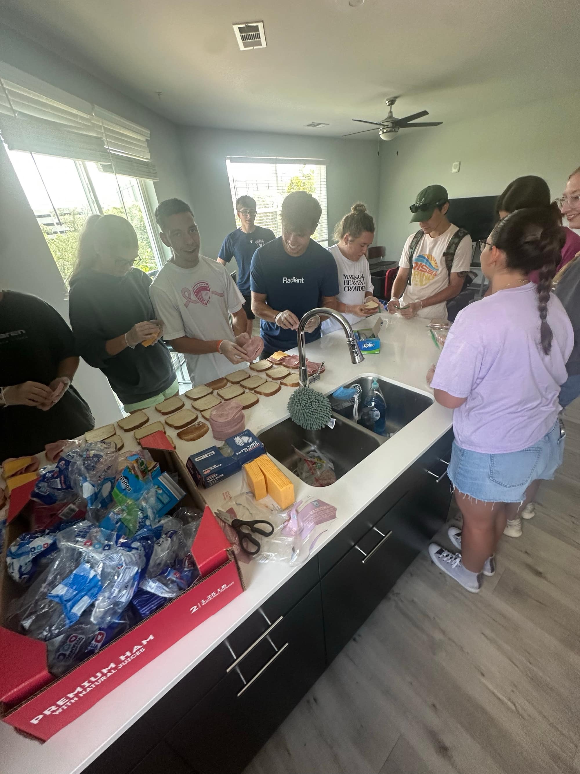 Making Heaven Crowded volunteers making sandwiches together at a kitchen counter in Tampa, FL