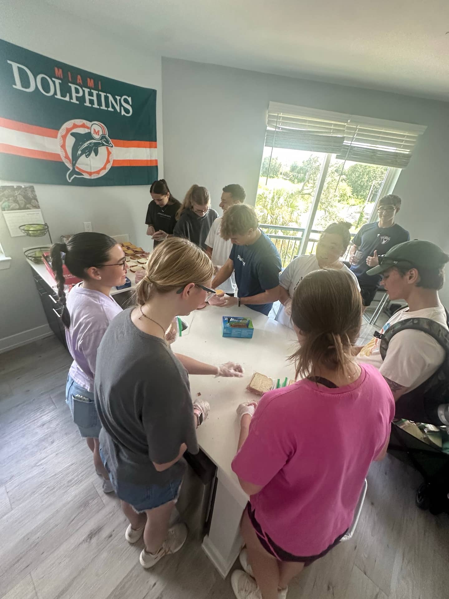 Volunteers gathered around a table indoors preparing food before a Making Heaven Crowded outreach