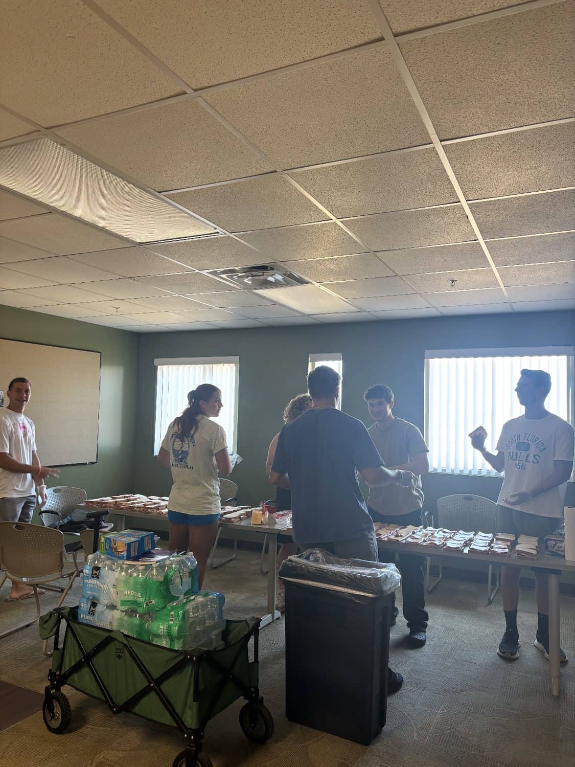 A room set up with tables and a supply cart where Making Heaven Crowded volunteers prepare for an outreach